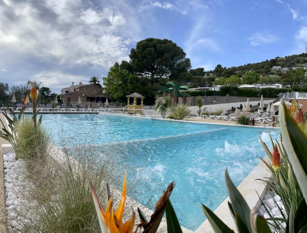 a large swimming pool with blue water at Mobil Home superbe Vue Mer St Raphaël in Saint-Raphaël