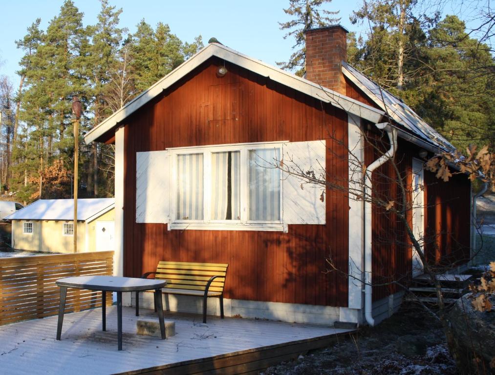 eine kleine Kabine mit einem Tisch und einer Bank auf einem Deck in der Unterkunft Erikssund in Erikssund