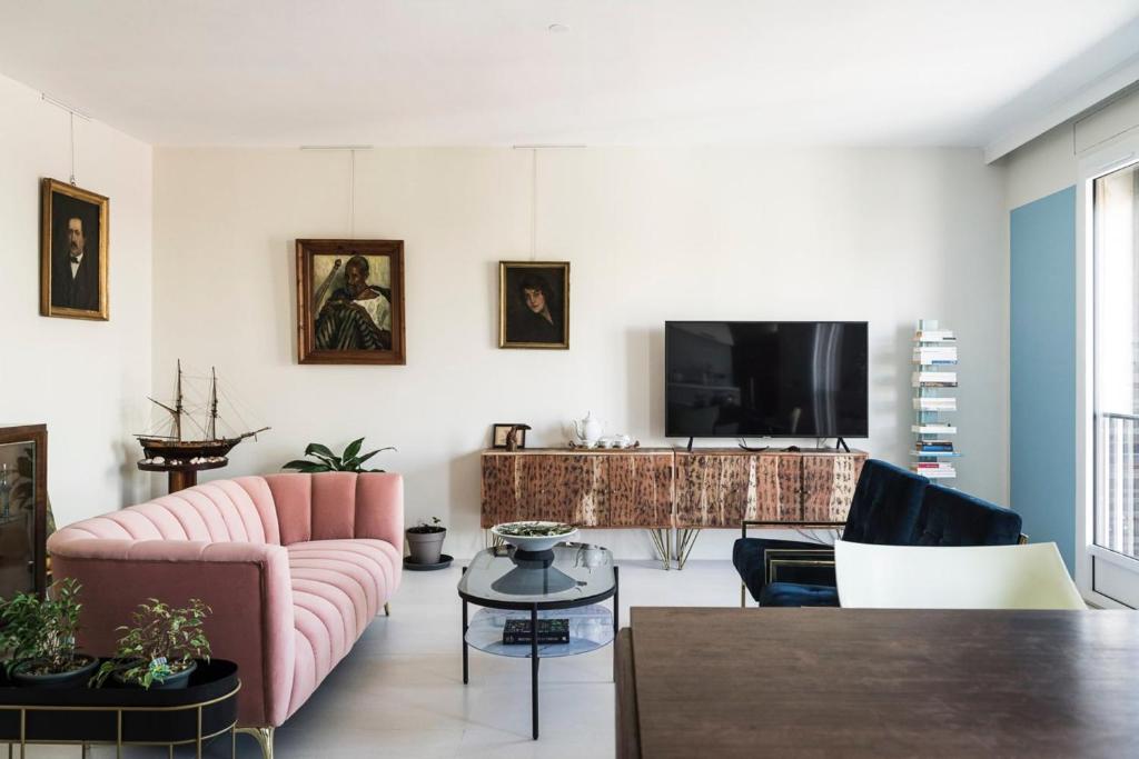 a living room with pink furniture and a flat screen tv at Elegant Apt In The Historical Center Of Avignon in Avignon