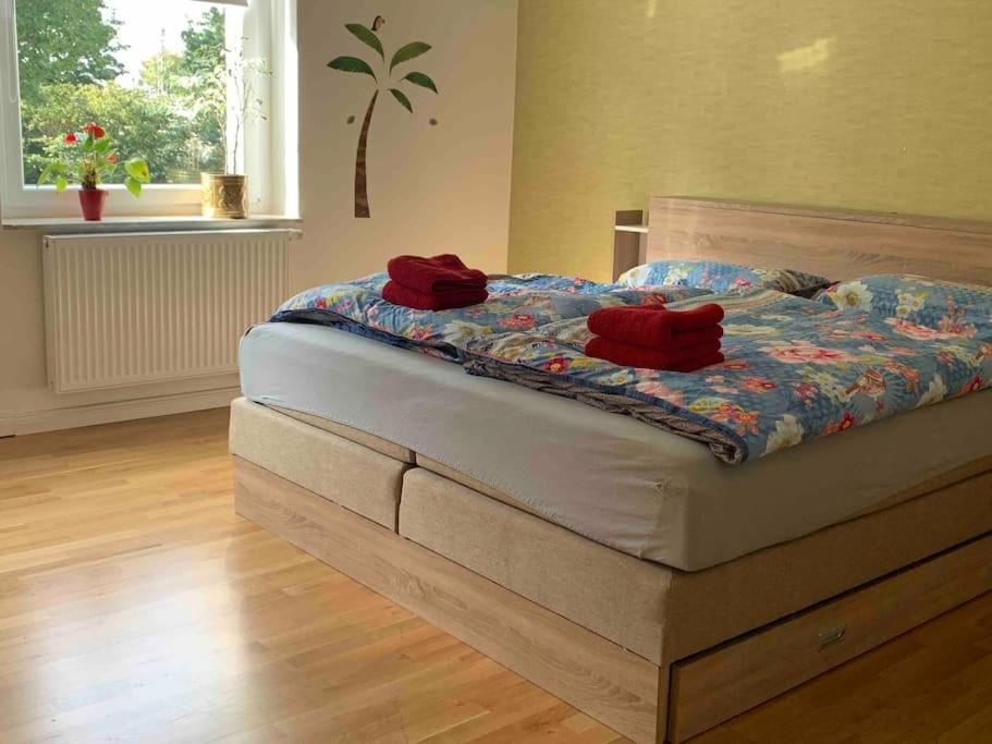 a bed with red pillows on it in a bedroom at Mitten im Ruhrgebiet immer Willkommen, wlan , Netflix, Parking Free, 100m2 flat in Oberhausen
