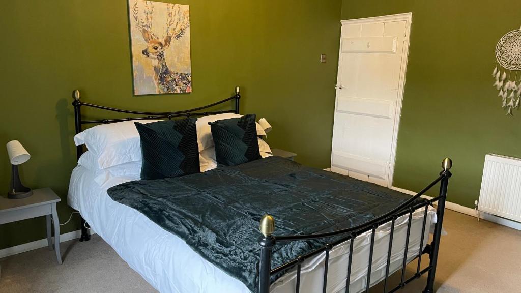 Holmrook的住宿－Holmside Cottage，一间卧室配有一张带绿色墙壁的床