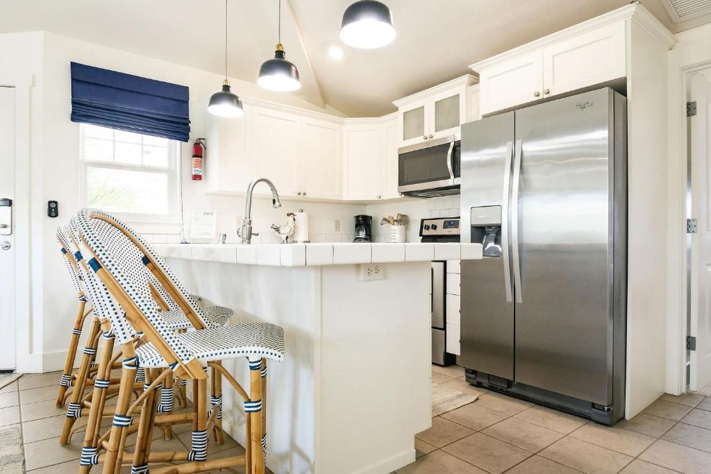 uma cozinha com armários brancos e um frigorífico de aço inoxidável em Plantations at Princeville 821 condo em Princeville