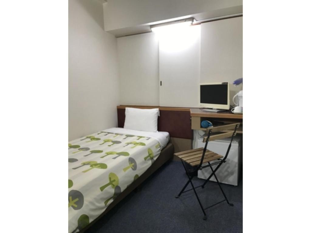 a bedroom with a bed and a desk with a computer at Rico Hotel Kokura - Vacation STAY 22584v in Kitakyushu