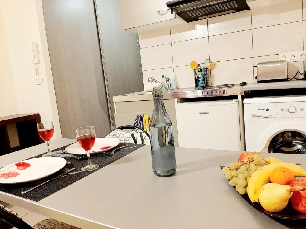 una cocina con 2 copas de vino y un plato de fruta en Charmant studio centre ville, en Le Puy en Velay