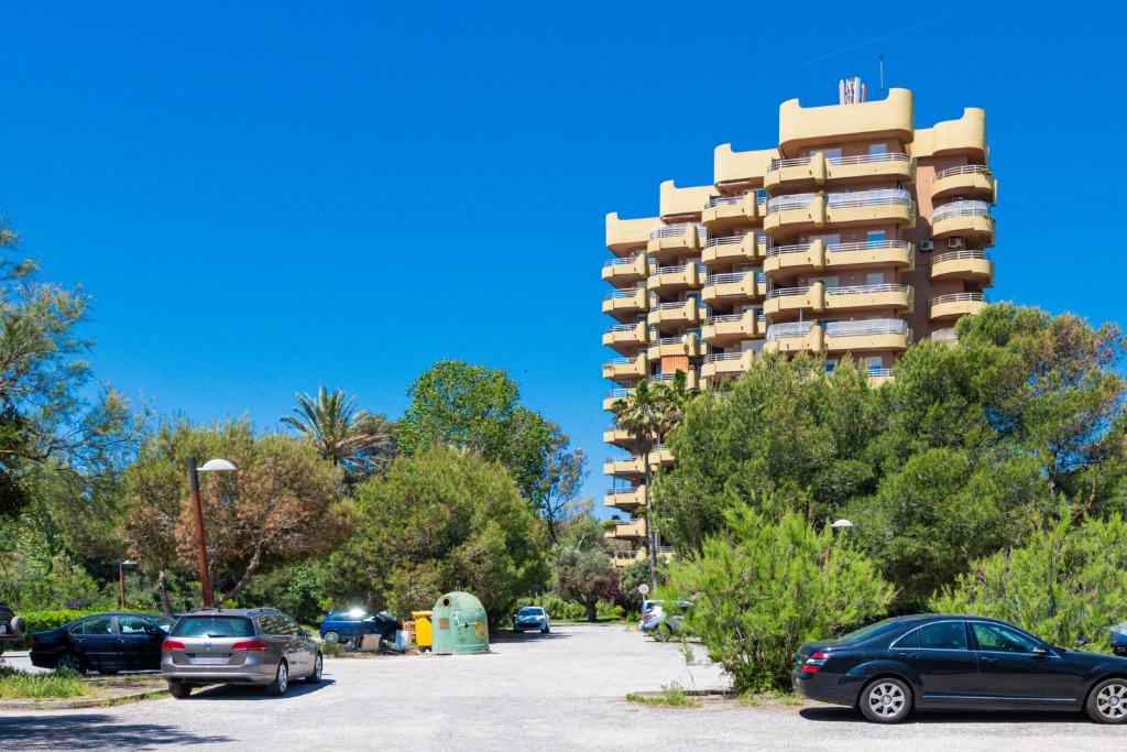 a parking lot with cars parked in front of a tall building at Salamar Saler Golf in El Saler