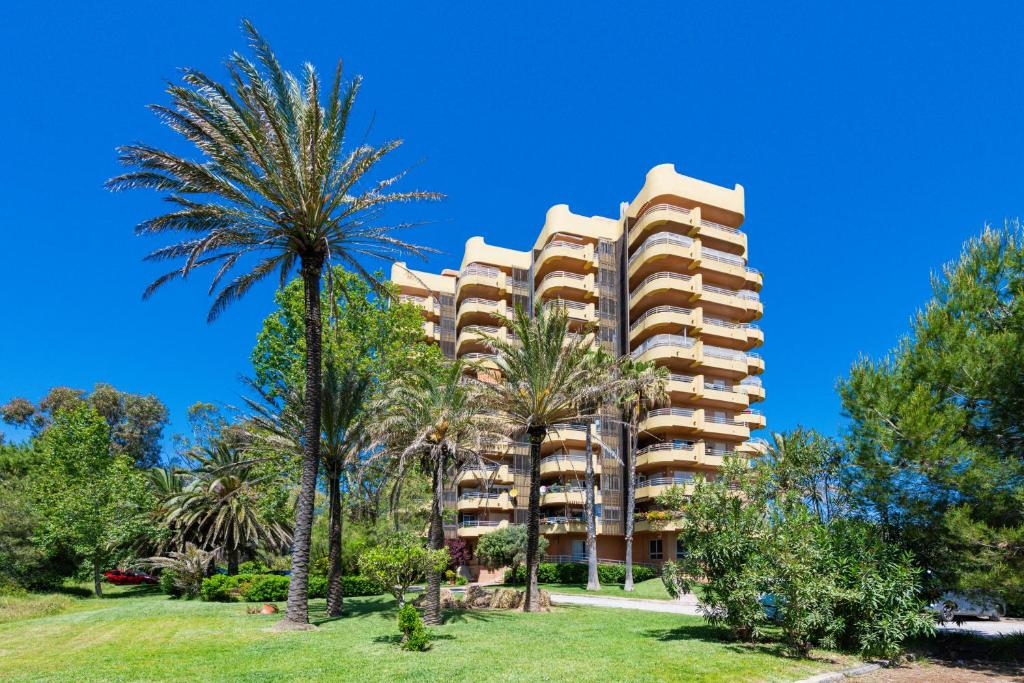 a building with palm trees in front of it at Salamar Saler Golf in El Saler