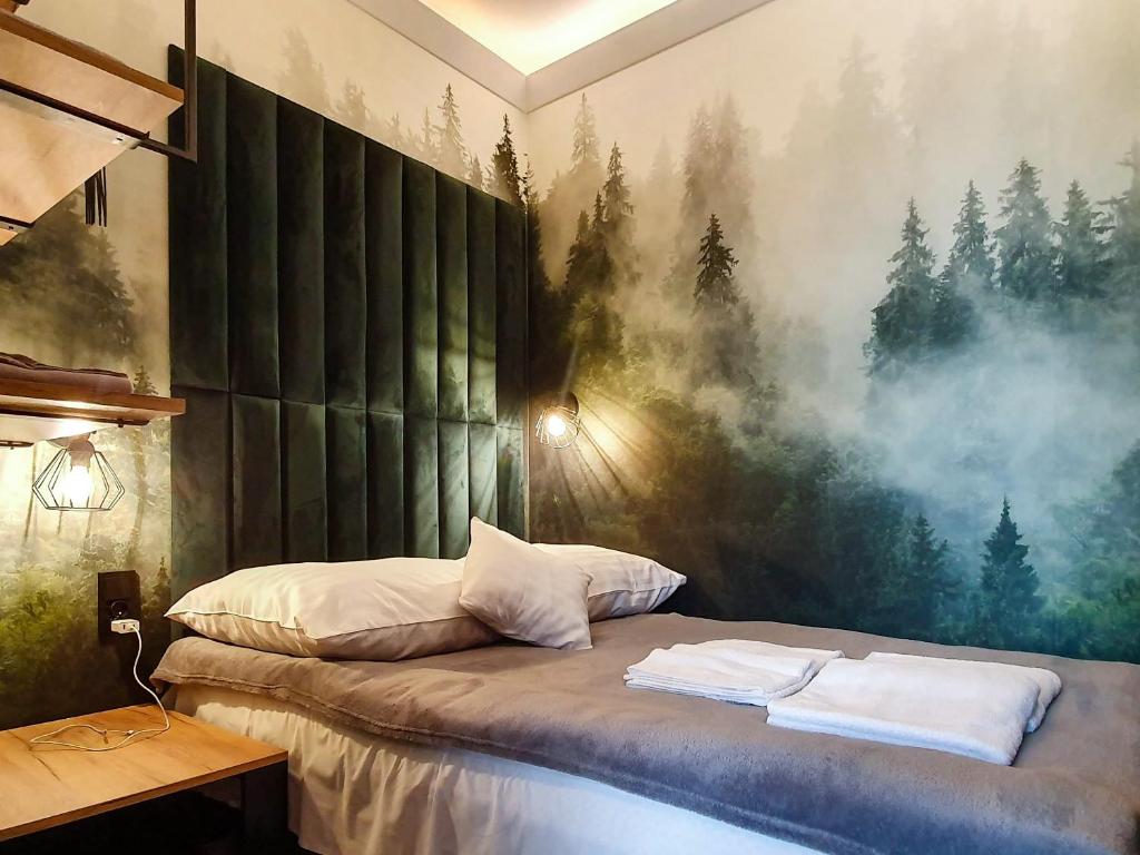 a bedroom with a bed with a painting on the wall at helloGdańsk in Gdańsk