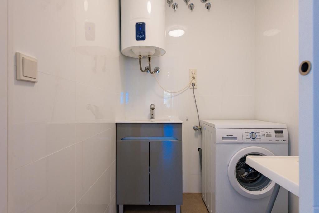 a bathroom with a washing machine and a sink at Salamar Saler Golf in El Saler