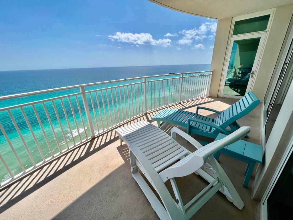 a balcony with two beach chairs and the ocean at AQUA RESORT! Beachfront, 3 Bedroom Condo! 2 Bedrooms Beach Front! Sleeps 7! Free Beach Chairs by Dolce Vita Getaways PCB in Panama City Beach