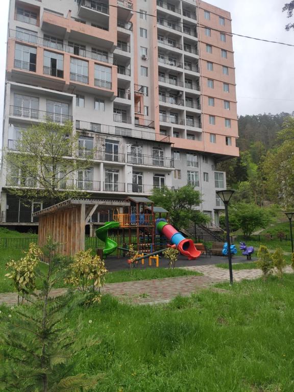 a playground in front of a large building at Apartment Likani in Borjomi