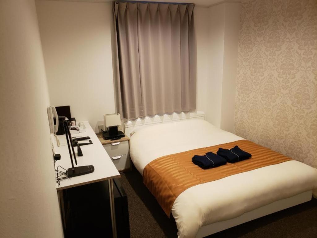 HOTEL CARNA A - Vacation STAY 53725v في كوماموتو: غرفة في الفندق مع سرير ومكتب