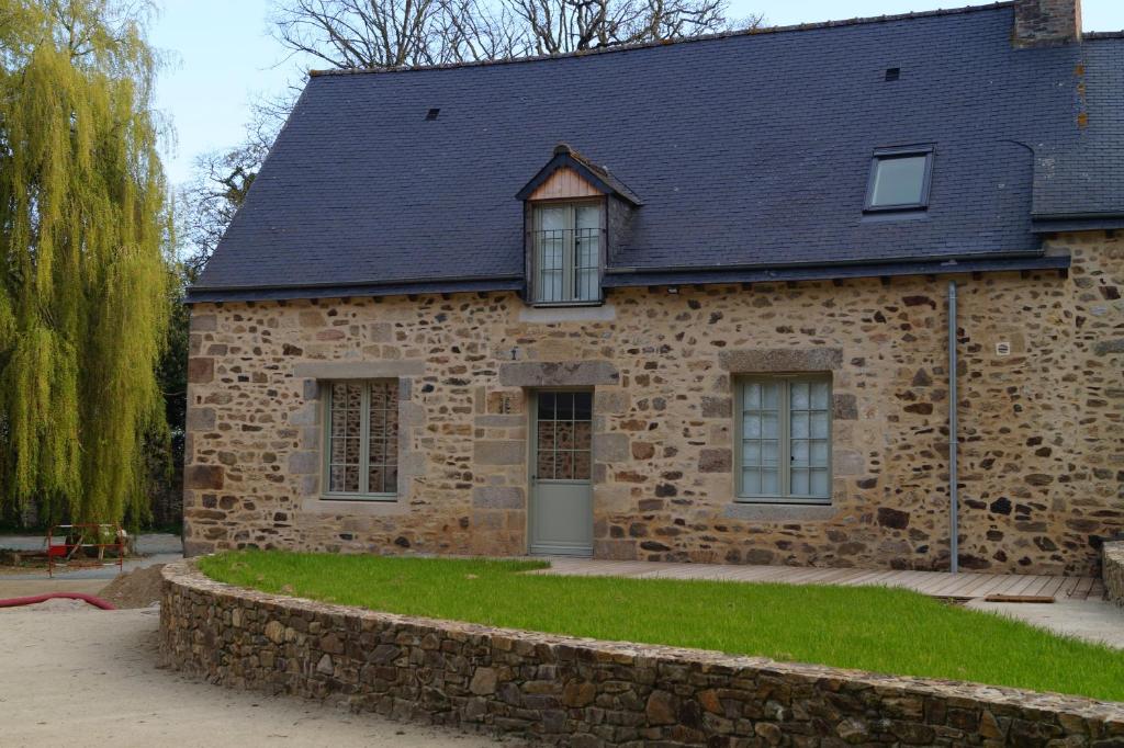 an old stone house with a stone wall at Les Terrasses de La Moglais in Lamballe