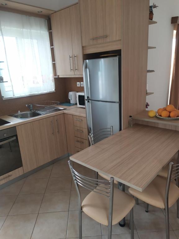 kuchnia ze stołem i lodówką ze stali nierdzewnej w obiekcie Panoramic Balos Sea View House w mieście Kisamos