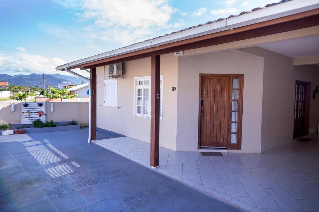 a house with a balcony with a wooden door at Recanto do Mar Pinheira in Palhoça