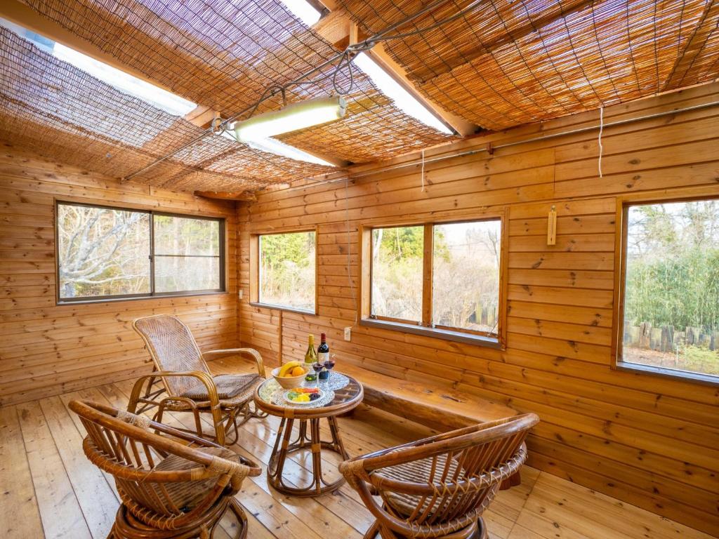 a room with a table and chairs in a log cabin at MOCHA House - Vacation STAY 12999 in Nasu-yumoto