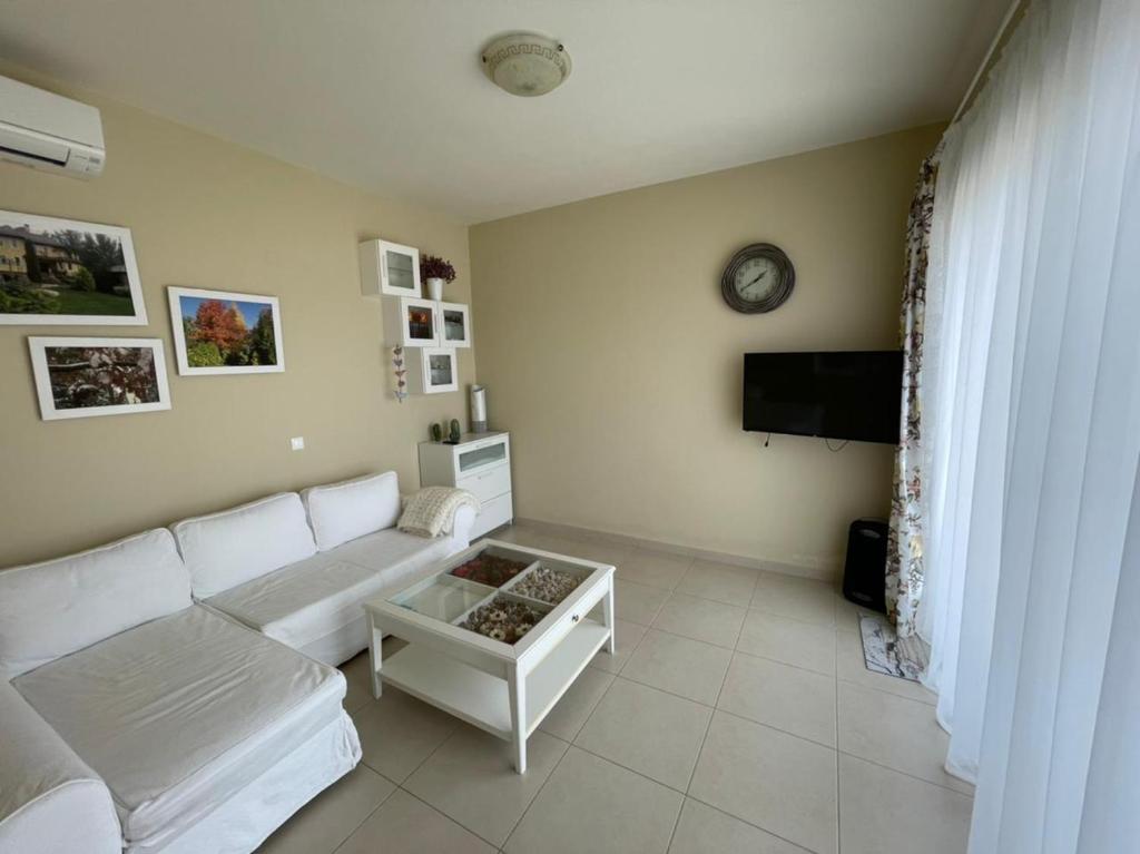 a living room with a white couch and a tv at Villa Natalia in Tolo