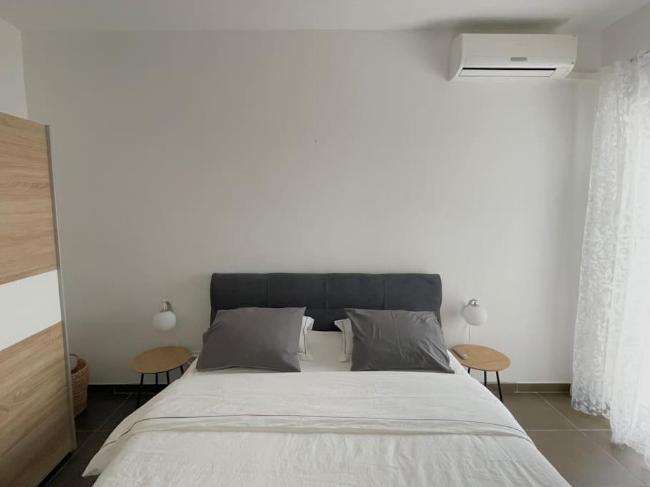 een slaapkamer met een groot bed en 2 tafels bij Appartement MB - Logement 3 chambres - Drage in Drage