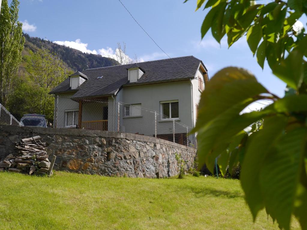 una casa con una pared de piedra frente a un patio en Maison de montagne proche Gavarnie 12-14 personnes, en Gèdre