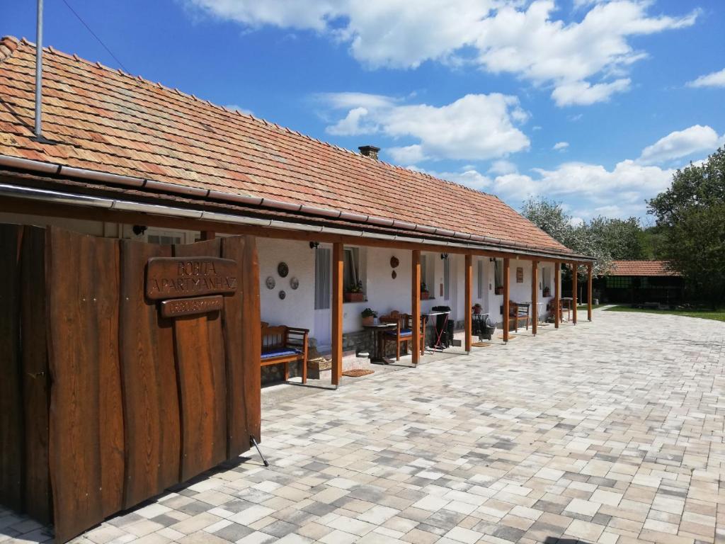 an outside view of a building with a patio at Bóbita Apartmanház in Szilvásvárad