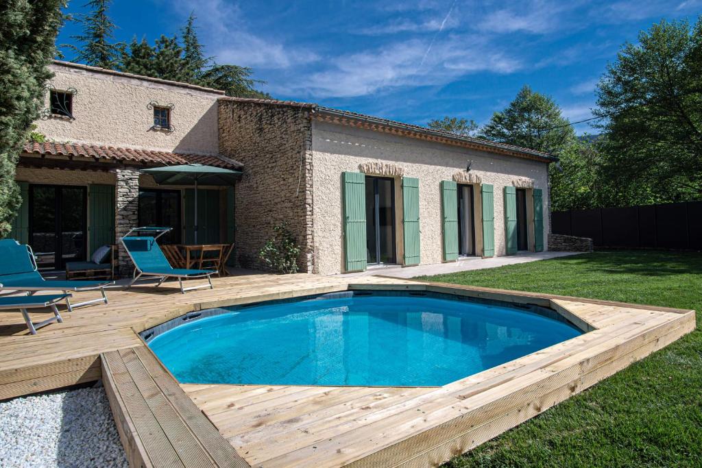 een zwembad met een houten terras naast een huis bij Maison idéale pour les familles avec piscine privée - Fontaine-de-Vaucluse in Fontaine-de-Vaucluse