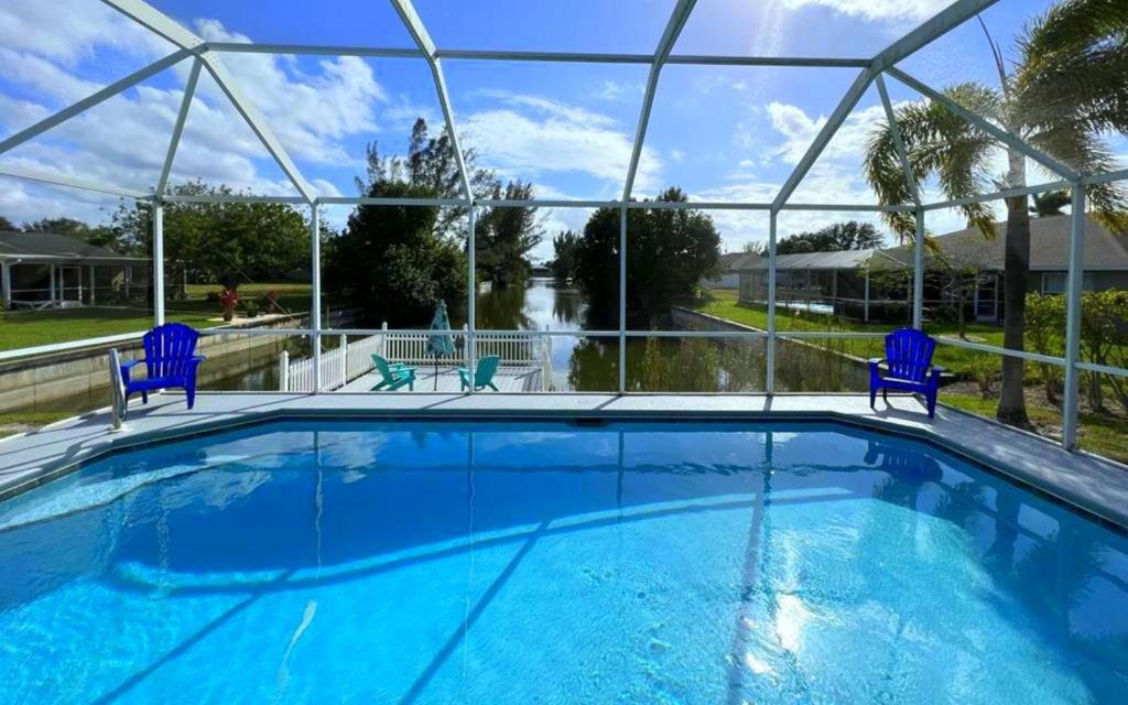 una gran piscina con sillas azules y vistas en !NEW! Villa Sunshine private Pool en Cape Coral