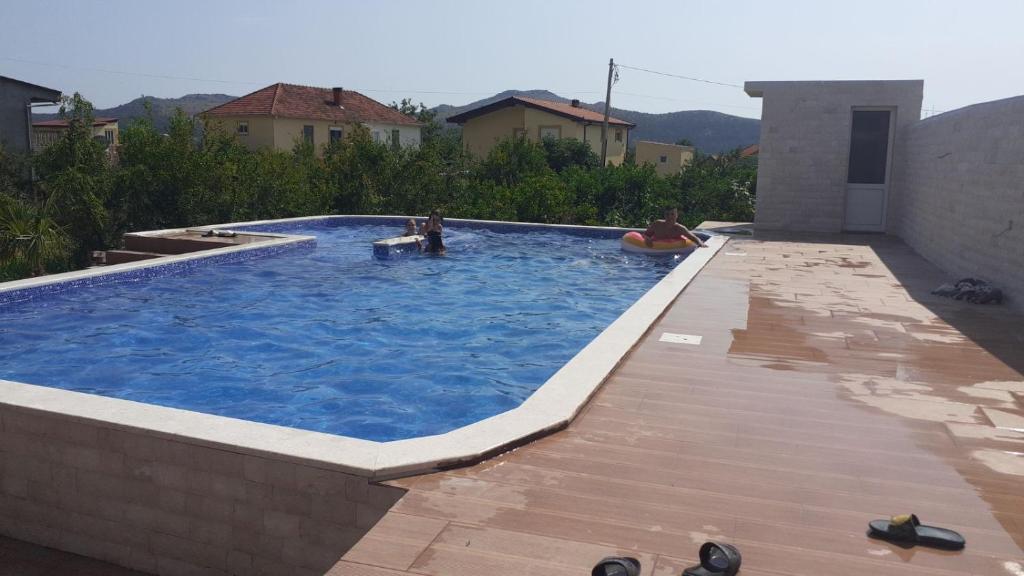 a swimming pool with two people in the water at Villa Nilić in Bar