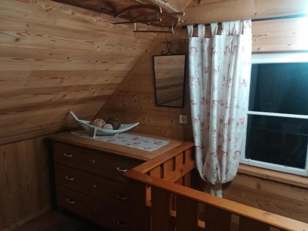 Dormitorio en cabaña de madera con vestidor y ventana en Ferienhaus Pliescherhof, en Turnau