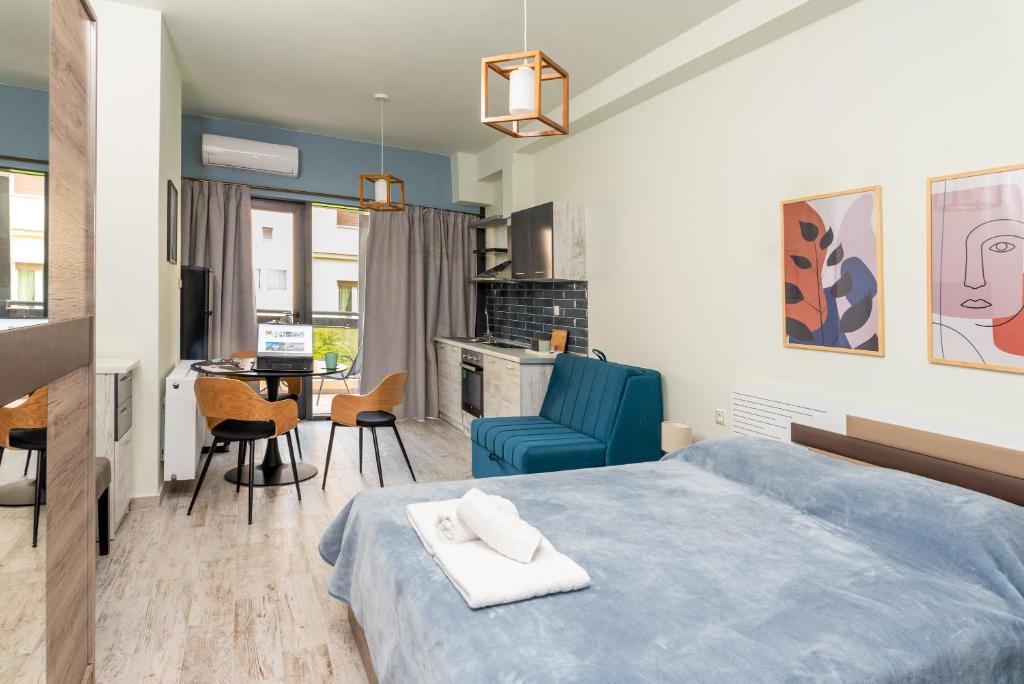 a bedroom with a blue bed and a table and chairs at CENTRAL ROYAL DREAM -Kiki in Volos