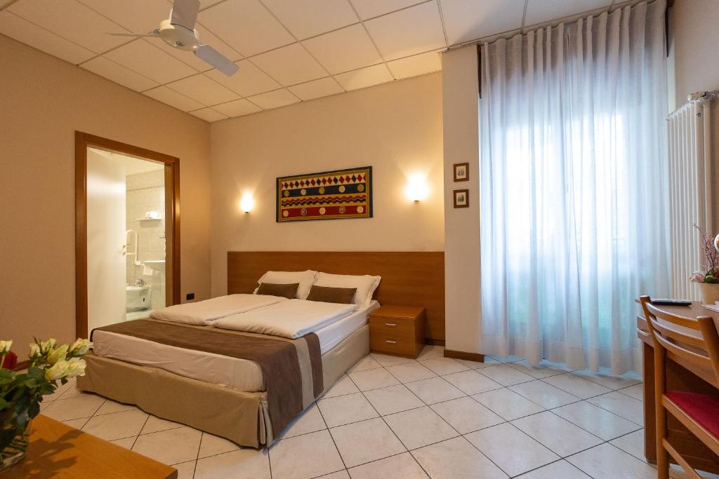 a bedroom with a bed and a large window at La Mimosa Lazise in Lazise