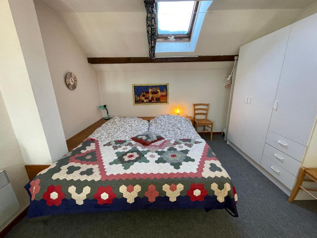 1 dormitorio con 1 cama con edredón en Plénouze, en Autrans