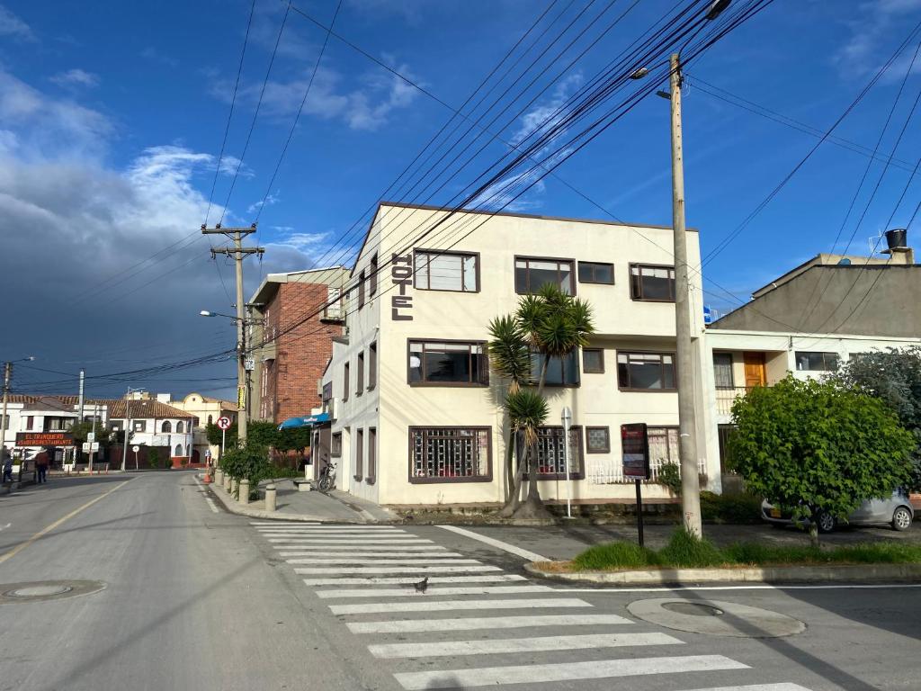 una calle vacía con un edificio blanco en la esquina en Hotel Rook INN, en Paipa