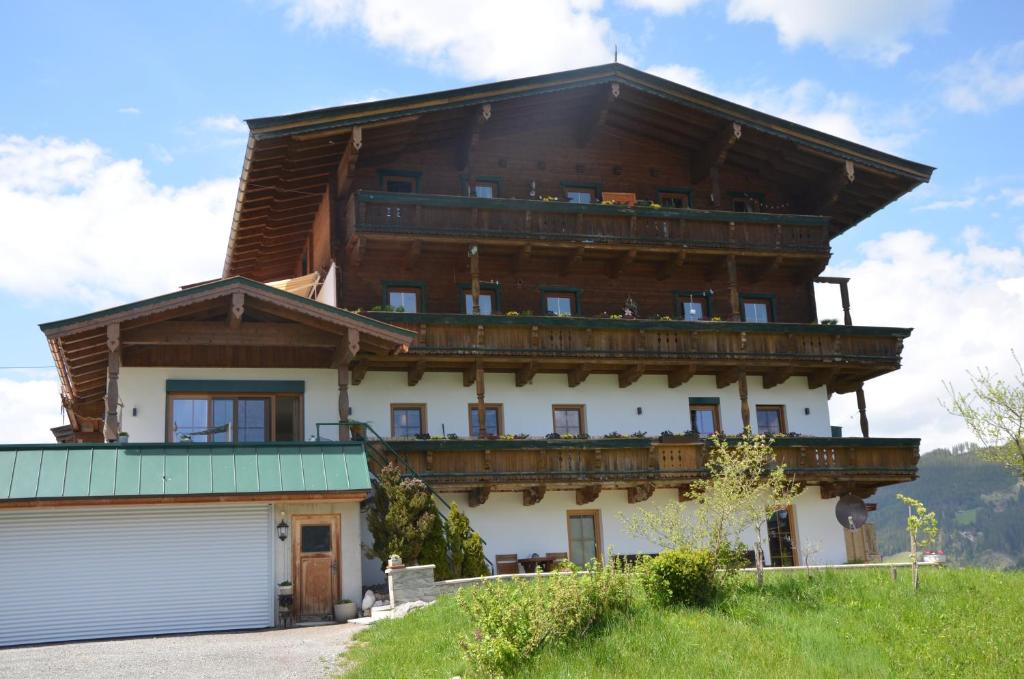 a large house with a balcony on top of it at Bergbauernhof Obergaisberg in Kirchberg in Tirol