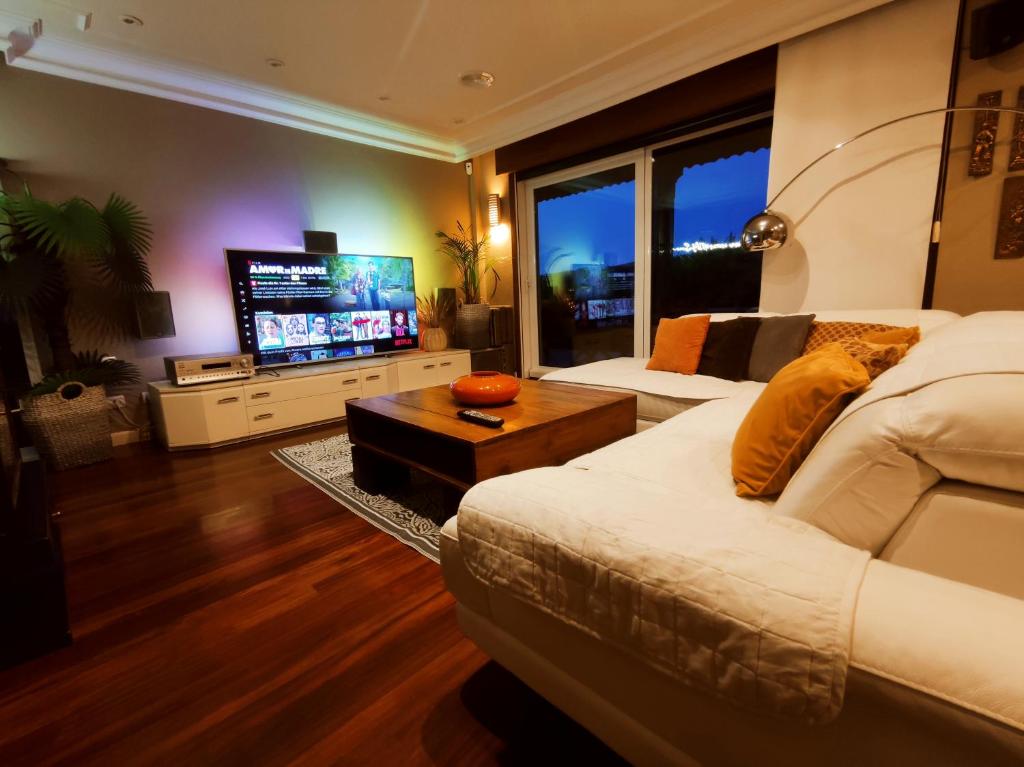 una camera con un grande letto e una TV di HHC - Holidays House Compostela a Santiago de Compostela