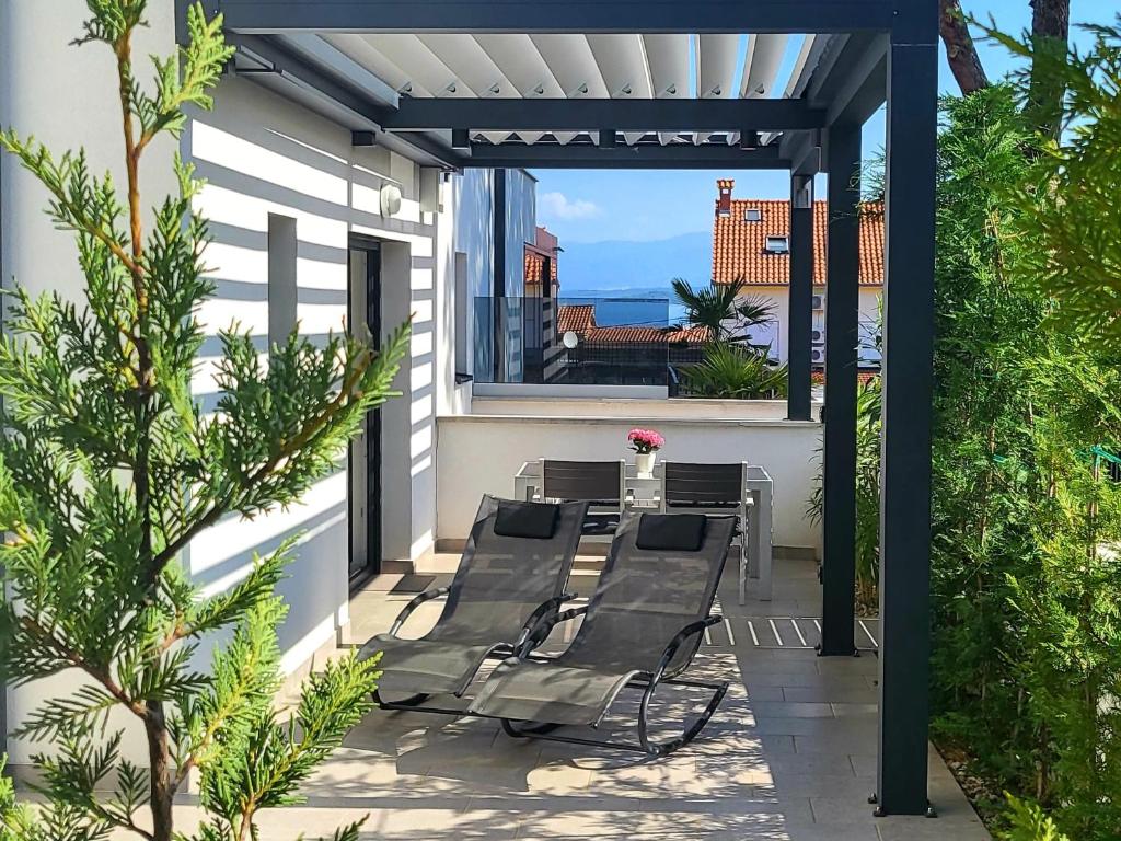 a patio with a table and chairs on a balcony at Apartments Elle Luxury Vantačići in Malinska