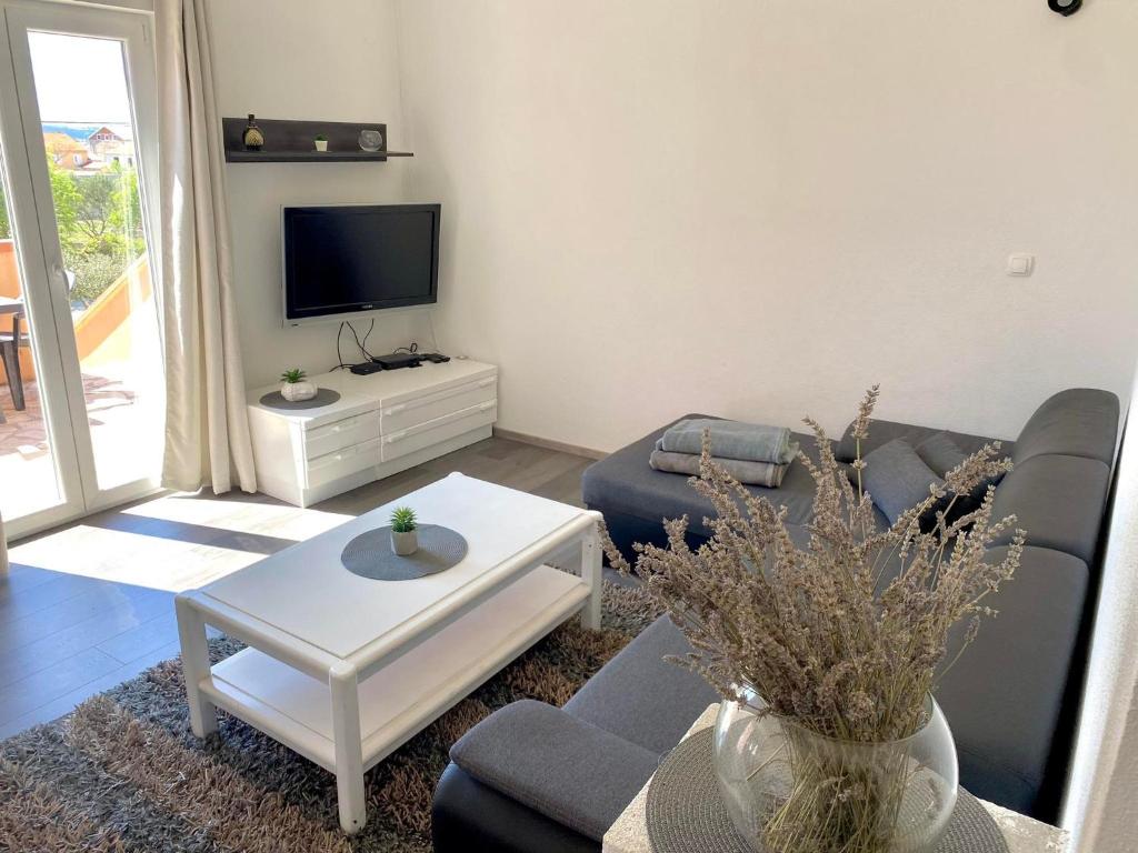 a living room with a couch and a tv at Apartman Ritta in Biograd na Moru