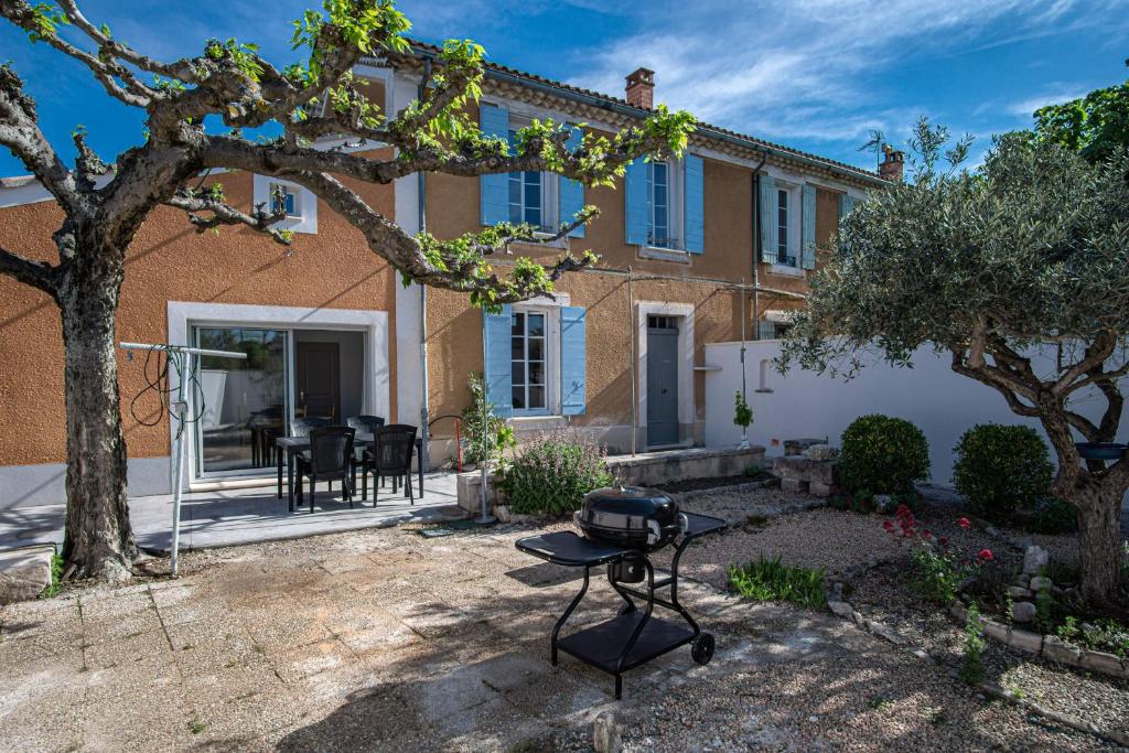une maison avec un barbecue dans la cour dans l'établissement Maison avec jardin proche du centre-ville Isle-sur-la-Sorgue, à LʼIsle-sur-la-Sorgue