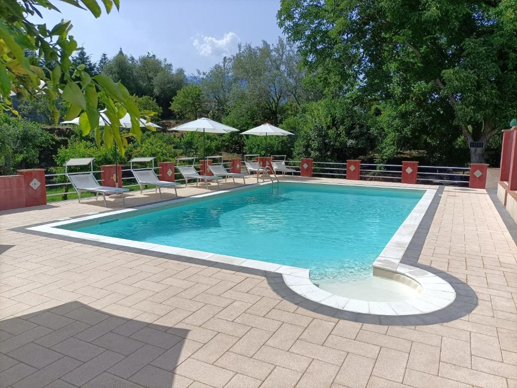 a swimming pool with chairs and a table at Borgo Zaccanazzo in Acireale