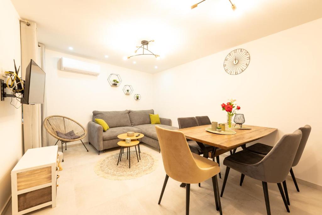 een woonkamer met een bank en een tafel en stoelen bij Apartment Olive in Kaštela