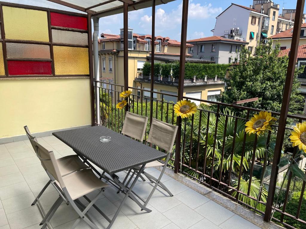 a balcony with a table and chairs and flowers at Appartamenti Aspromonte in Milan