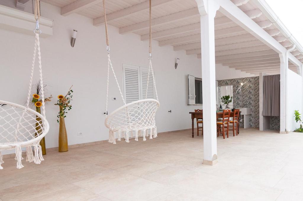 a living room with white chairs and a table at Villa Marisa Holiday Home in Punta Prosciutto