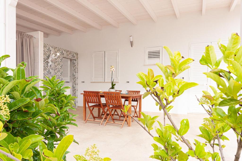 taras ze stołem i krzesłami z drewna w obiekcie Villa Marisa Holiday Home w mieście Punta Prosciutto