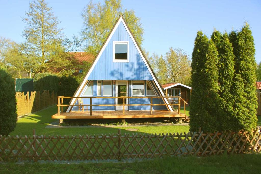 a small house with a blue roof on a yard at Ferienhaus Lüttje Swaan in Detern