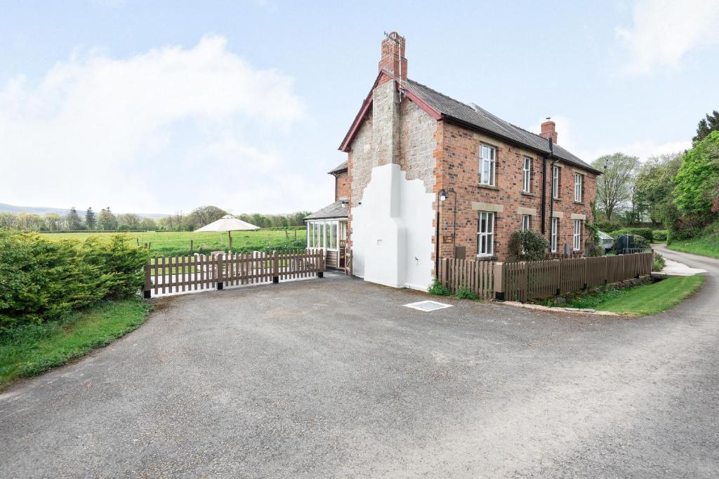 une ancienne maison en briques avec un portail et une clôture dans l'établissement 2 Siluria Cottage, à New Radnor