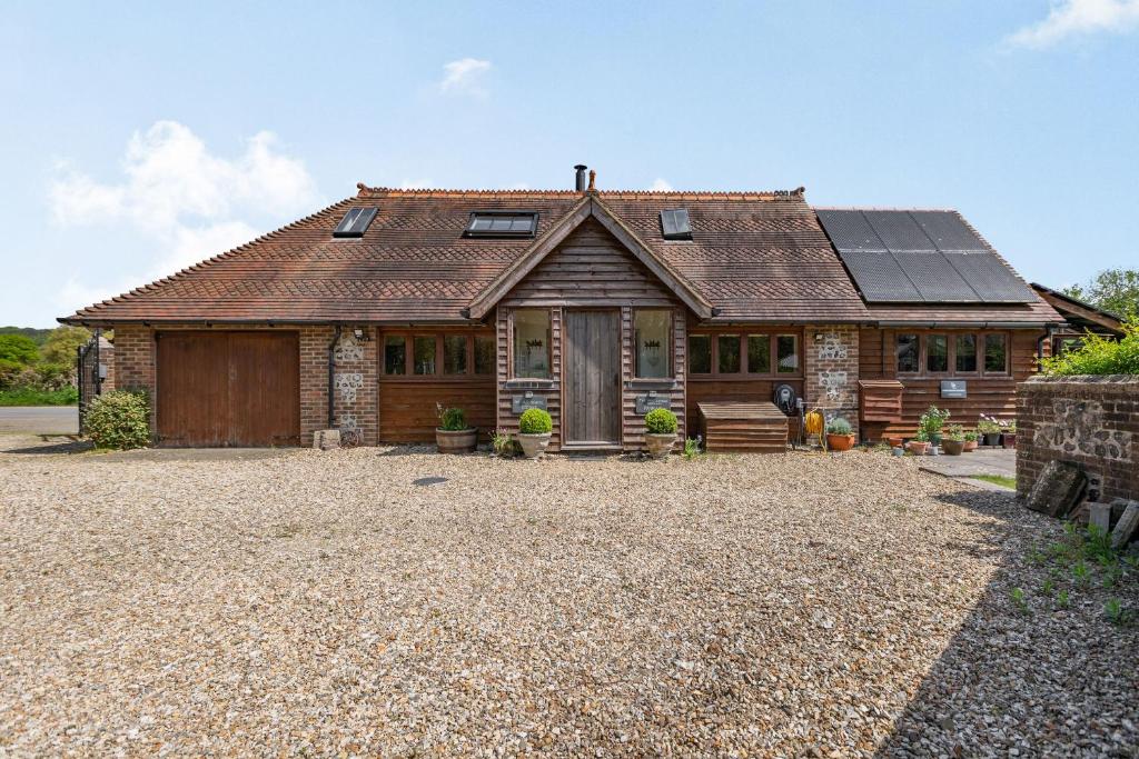 a house with a solar roof on a gravel driveway at The Old School Cottage in Woodsford