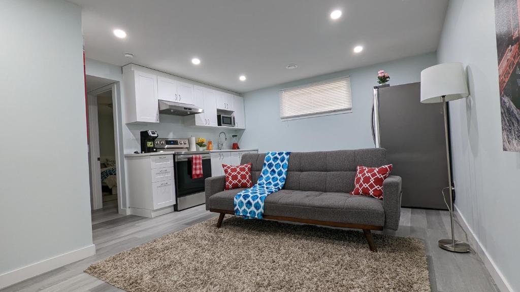 uma sala de estar com um sofá e uma cozinha em SERENE & MODERN 1BED SUITE + CLOSE TO AIRPORT em Regina