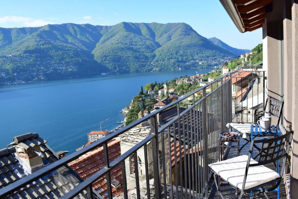 uma varanda com vista para um lago e para as montanhas em Romantic home with beautiful view lake of Como and Villa Oleandra em Laglio