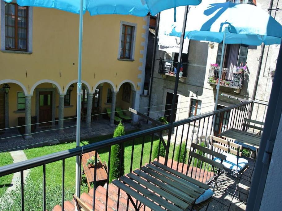 - un balcon avec un banc et un parasol dans l'établissement Appartamento AZZURRO, à Cannobio