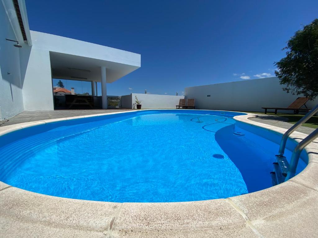 a large blue swimming pool in a house at Villa Família in Ponta Delgada