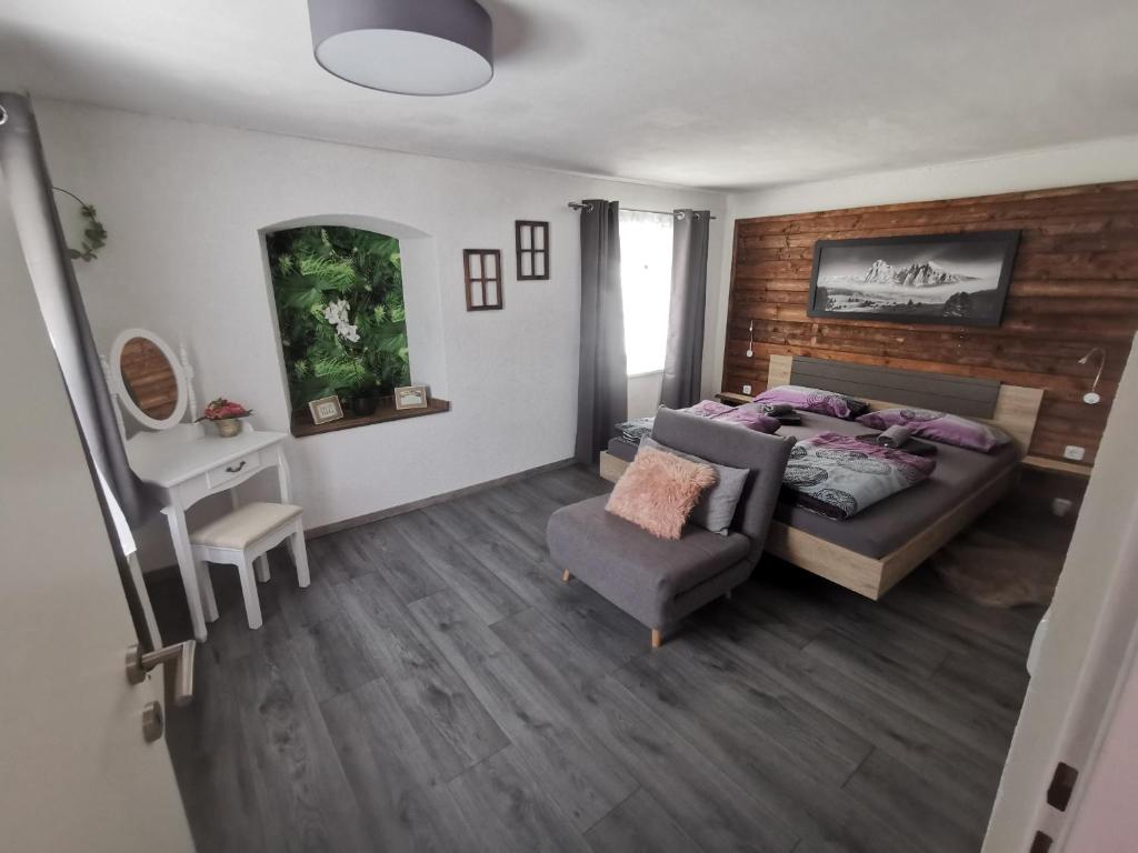 a bedroom with a bed and a chair and a desk at Ferienwohnung Rotheneder- Rupp in Niederndorf