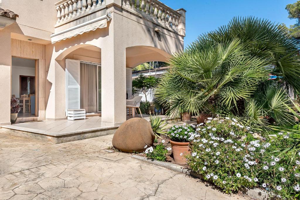 a house with a porch and some plants and trees at Villa Tamarells - Alcúdia in Alcudia